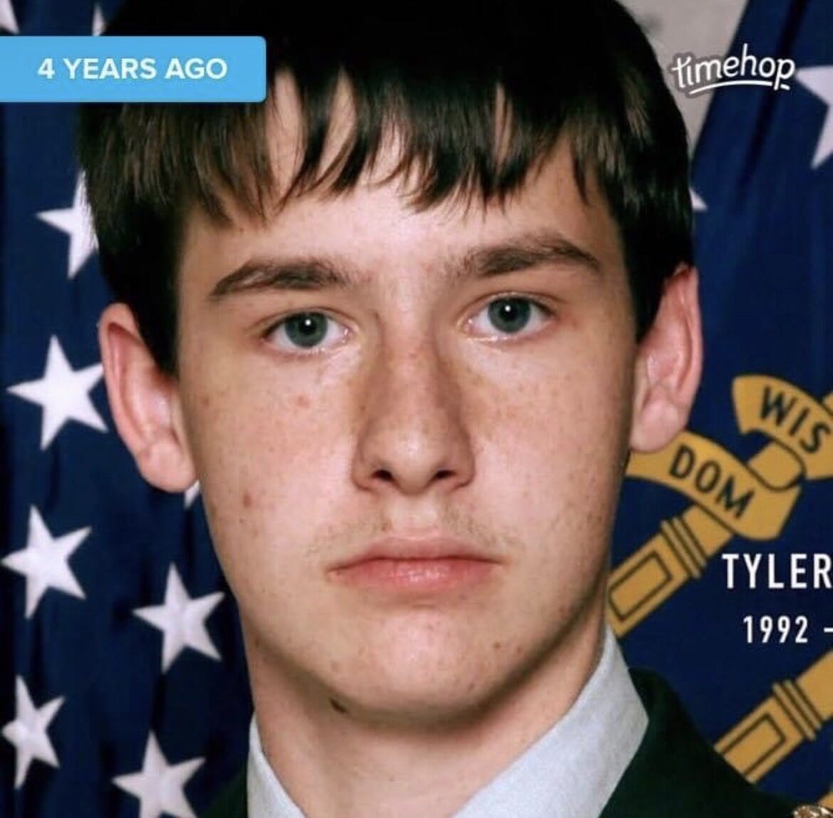 Tyler in his JROTC uniform in front of flags